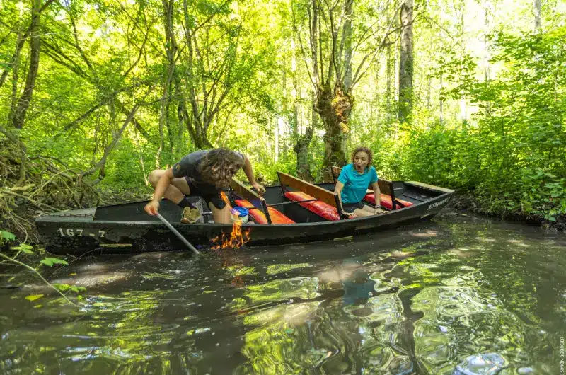 Feu sur l'eau lors d'une promenade en barque avec l'Embarcadère de la Venise verte Un batelier met le feu au méthane emprisonné dans la vase de la conche lors d'une promenade en barque dans le Marais poitevin